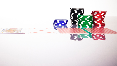 Artikelmotiv OASIS Spielersperrsystem Pokerkarten und Casino-Chips auf einem Glastisch
