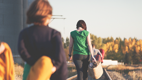 Datenverwaltung als Schlüssel zu gezielter Hilfe - mit dem HVF der HZD Rückenansicht von Frauen mit leichtem Gepäck, die an einem Bahngleis entlang laufen