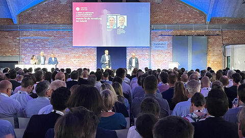 Impulse für die Verwaltung von morgen: der Zukunftskongress Staat & Verwaltung mit Staatssekretär Dr. Markus Richter vom BMI als Keynote-Speaker Blick über das Publikum hinweg auf die Vortragsbühne des Zukunftskongresses, wo Staatssekretär Dr. Markus Richter vom BMI die Keynote zur Veranstaltung gibt