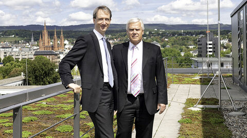 Dr. Ulrich Schmidtberg und Marcus Milas Zwei Männer stehen auf Dachterrasse. Im Hintergrund sieht man Wiesbaden
